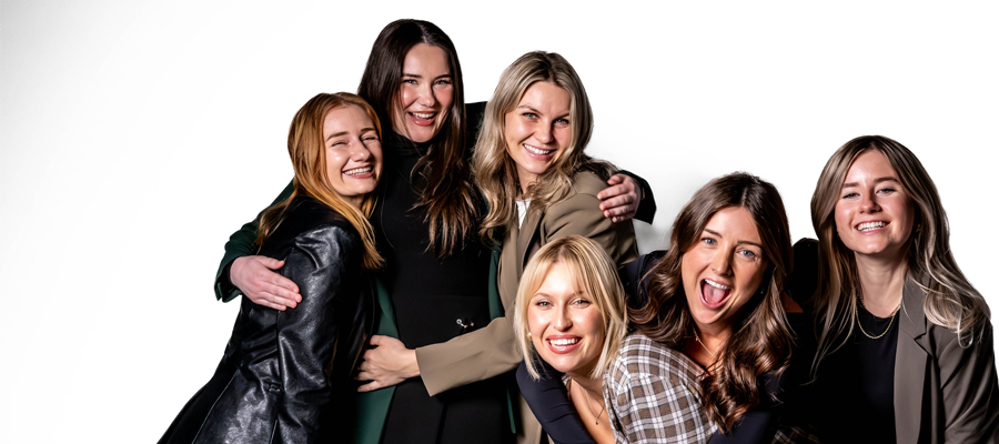 Collective Joy A bright, crisp studio portrait of six women laughing and embracing each other.